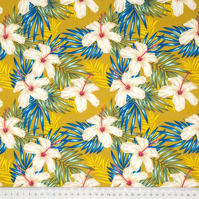 Tropical flowers printed on a gold cotton poplin fabric by Rose & Hubble with a cm ruler