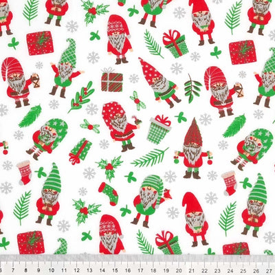 Gnomes and christmas presents are printed on a white polycotton fabric with a cm ruler
