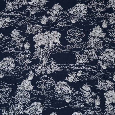A beautiful nature scene with trees and a riverside are printed in white on a navy viscose fabric.