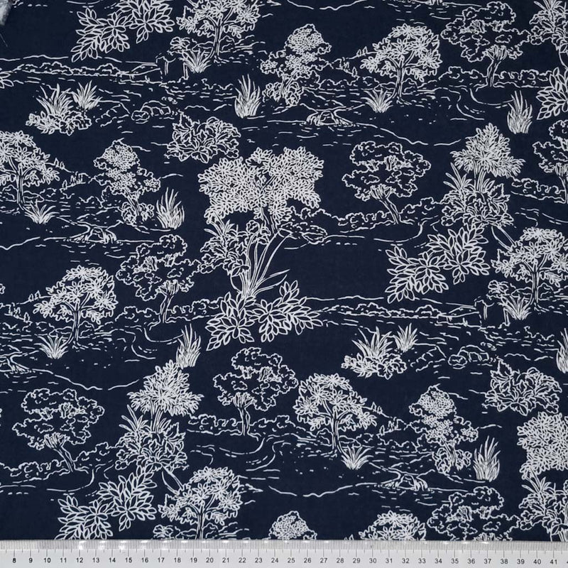 A beautiful nature scene with trees and a riverside are printed in white on a navy viscose fabric with a cm ruler