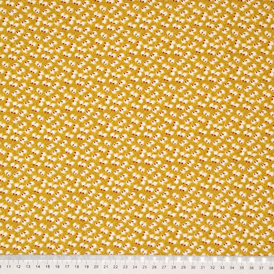 Ditsy white and wine coloured petals are printed on a mustard viscose dressmaking fabric with a cm ruler
