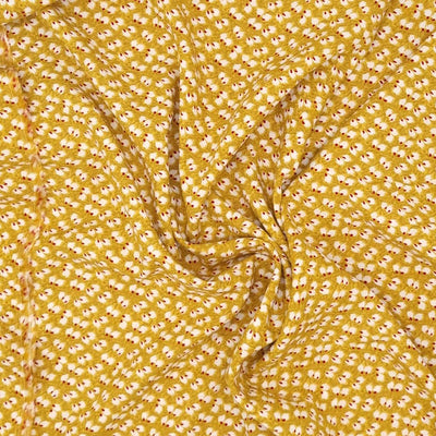 Ditsy white and wine coloured petals are printed on a mustard viscose dressmaking fabric