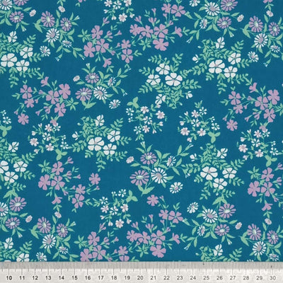 Calendula flowers are printed on this teal polycotton fabric with a cm ruler