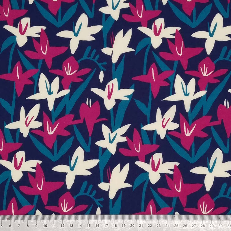Cerise and cream Lily flowers are printed on a navy polycotton fabric with a cm ruler