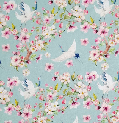 Birds and pink blossom printed on a pale aqua linen fabric