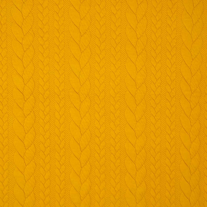 A plain mustard coloured cable knit dressmaking fabric
