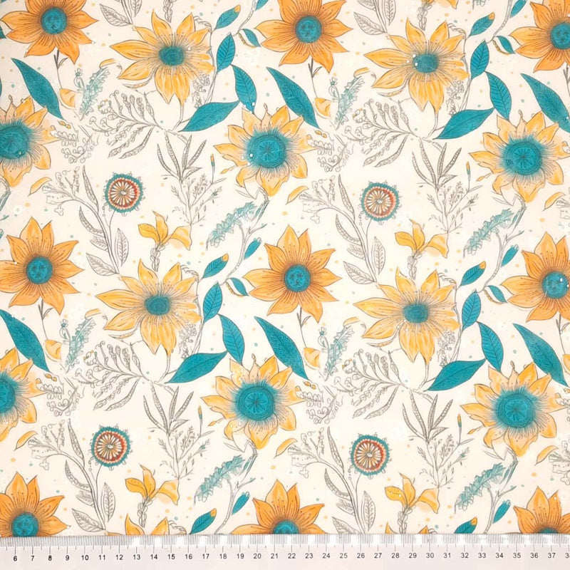 Teal and orange sunflowers are printed on a polycotton broderie anglaise fabric with a cm ruler