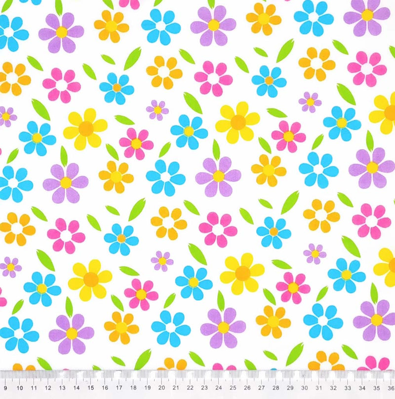 Brightly coloured flowers are printed on a white polycotton fabric with a cm ruler
