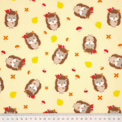 Cute hedgehogs and toadstools are printed on a cream polycotton fabric with a cm ruler