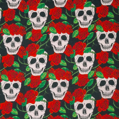 Skulls and red roses are printed on a black polycotton fabric