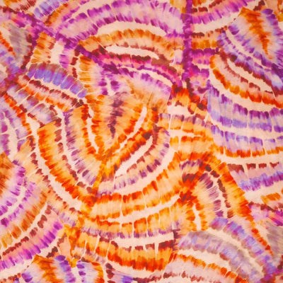 Purple and orange tie dye wheels are printed on a viscose fabric