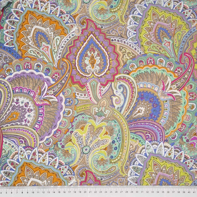 A viscose fabric printed with pastel coloured paisley print with a cm ruler