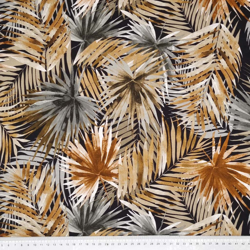 Golden and grey tropical leaves are printed on a black viscose fabric with a cm ruler