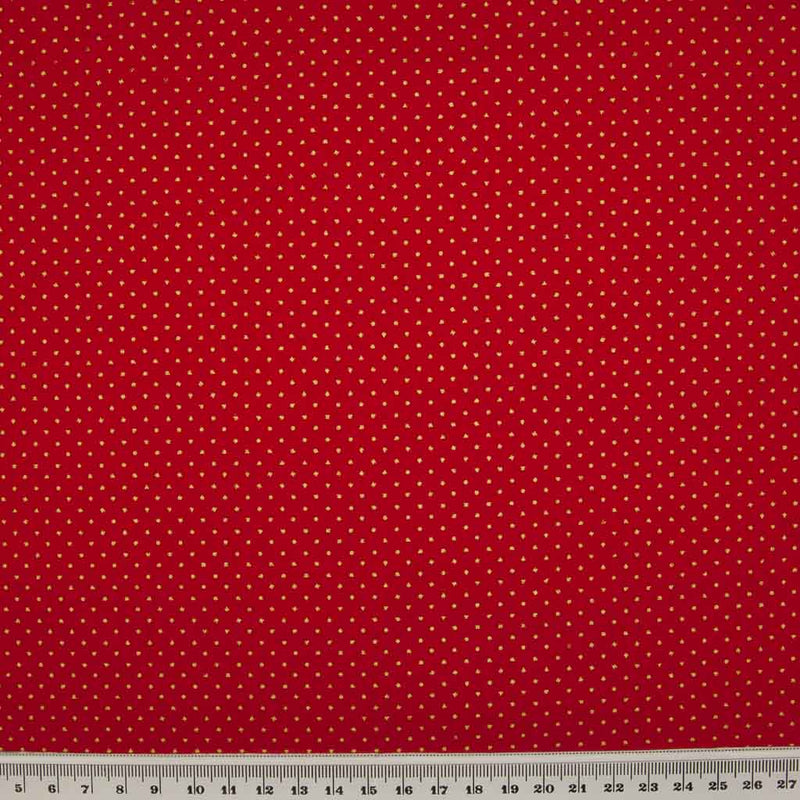 2mm gold lacquer pin spots are printed on a red cotton christmas fabric with a cm ruler at the bottom
