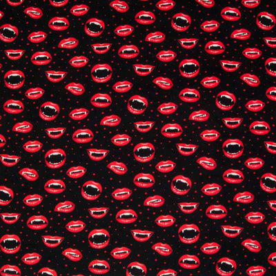 Vampire mouths with fang teeth and bright red lips are printed on a black, 100% cotton halloween fabric