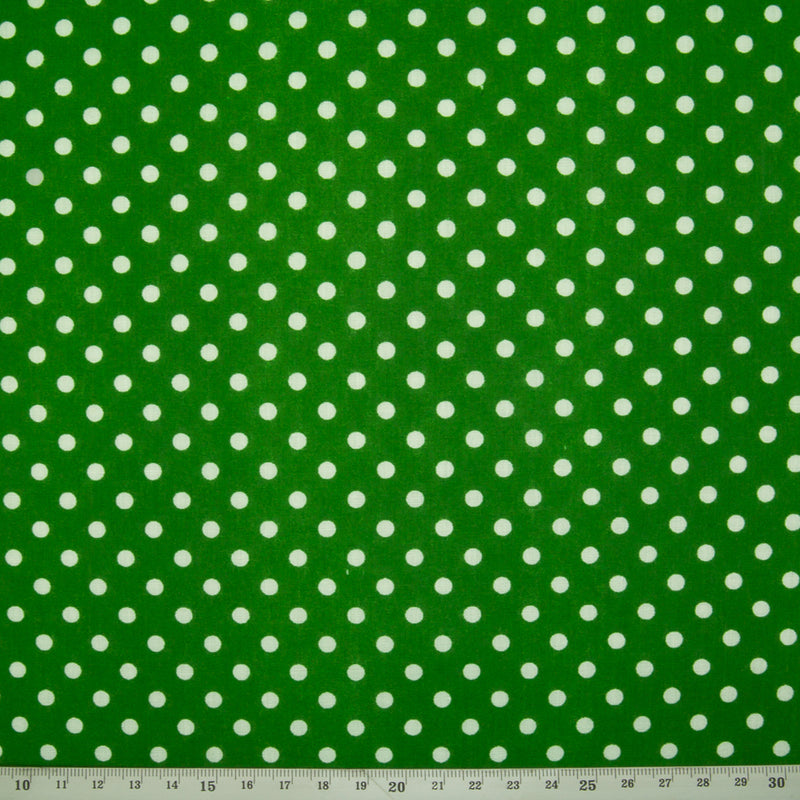 White spots printed on a green polycotton fabric