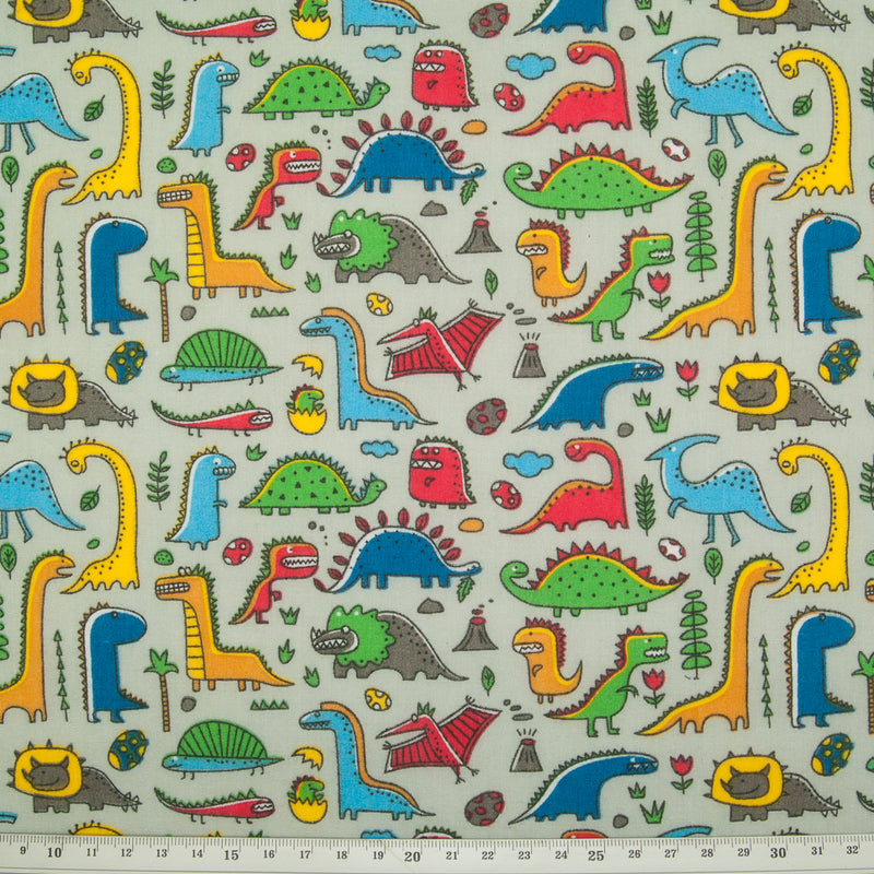 colourful cartoon dinosaurs printed on a silver polycotton fabric with a cm ruler