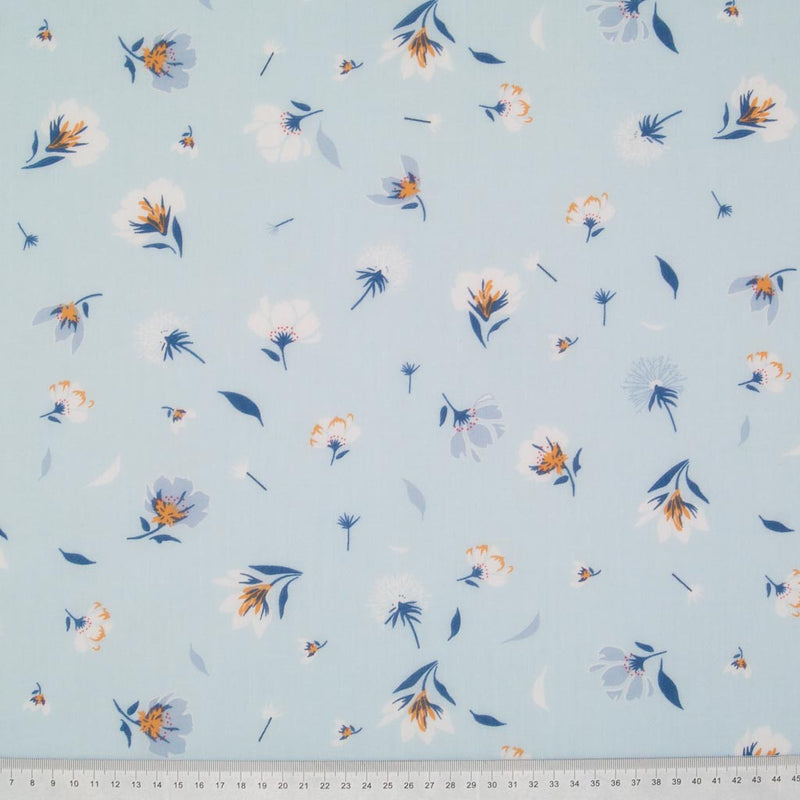Pretty dandelions are printed on a sky blue polycotton fabric with a cm ruler at the bottom