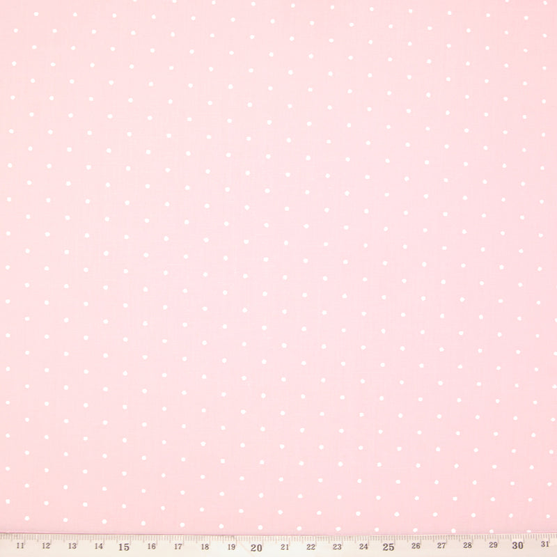 White pin spots printed on a pale pink polycotton fabric