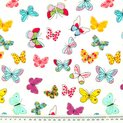 Brightly coloured Butterflies printed on cotton poplin fabric by Rose and Hubble with ruler for size perspective
