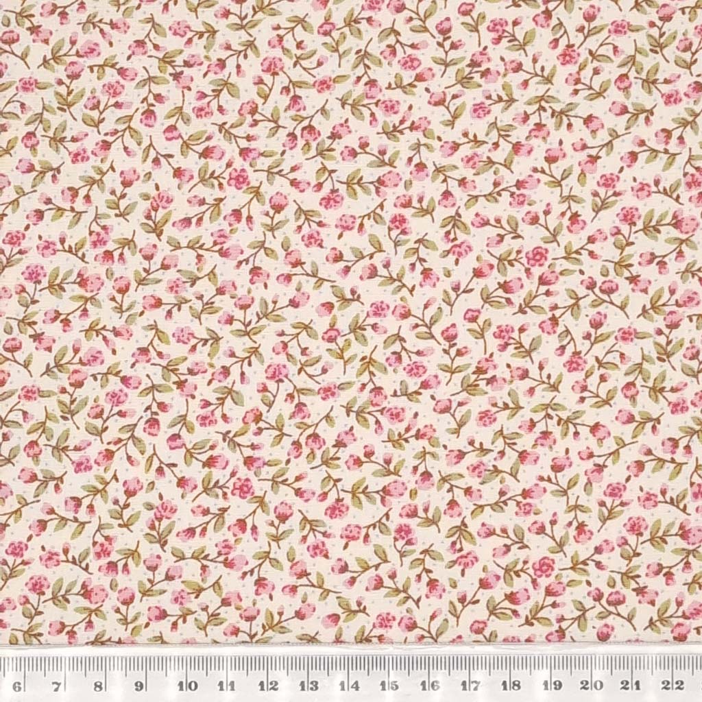 A ditsy pink floral pattern is printed on a cream Rose & Hubble cotton poplin fabric with a cm ruler