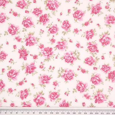 Dusky pink roses are printed on a sky ivory cotton poplin fabric by Rose & Hubble with a cm ruler