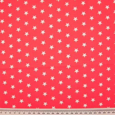 10mm white stars are printed on a red polycotton fabric with a cm ruler at the bottom