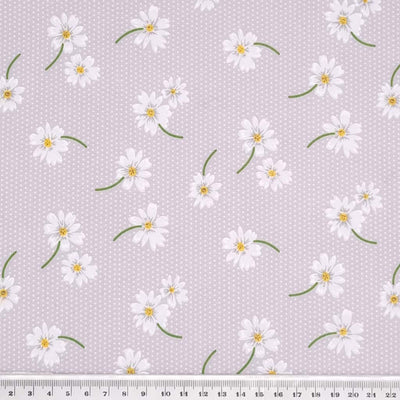 White daisies in a scattered pattern are printed on a silvery grey/lilac polycotton fabric with tiny white spots with a cm ruler