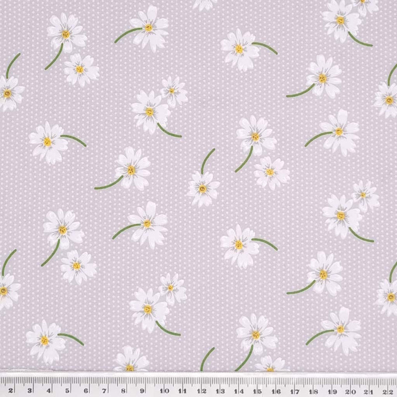 White daisies in a scattered pattern are printed on a silvery grey/lilac polycotton fabric with tiny white spots with a cm ruler