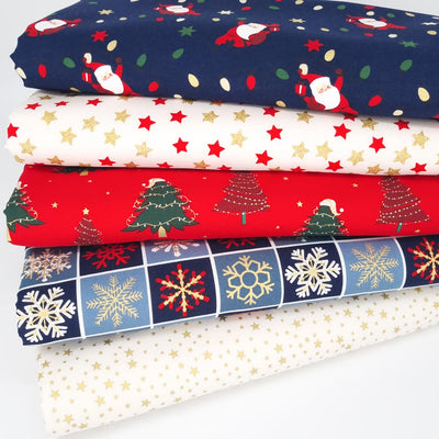 A christmas fat quarter bundle with santa and fairy lights on a navy cotton fabric, stars and trees
