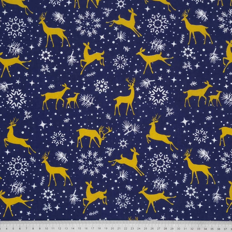 Prancing christmas reindeer with pretty stars and snowflakes are printed on a navy polycotton fabric with a cm ruler at the bottom