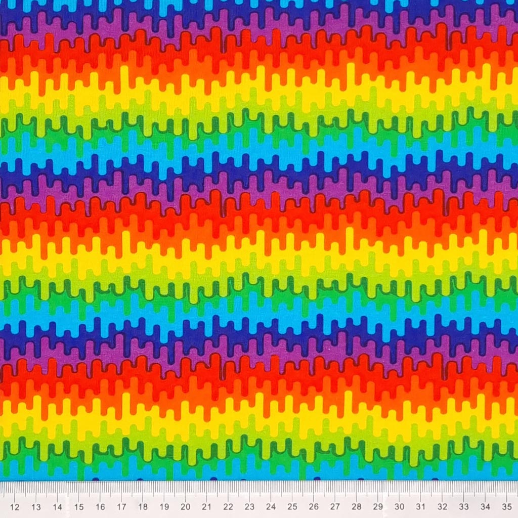 Brightly coloured rainbow swiggles printed on a 100% cotton jersey fabric with a cm ruler at the bottom