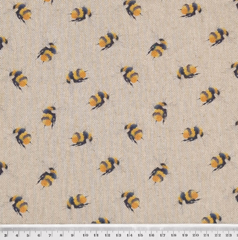 Miniature bumblebees printed on a craft canvas fabric with a cm ruler