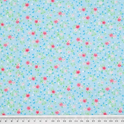 A delicate ditsy floral polycotton in turquoise. with a cm ruler