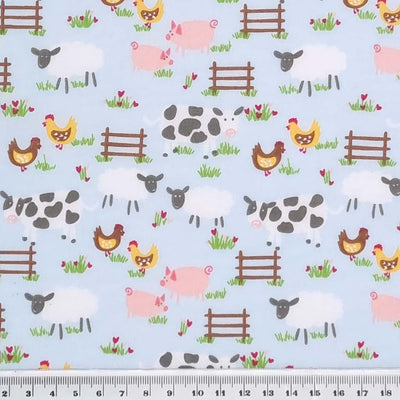 Chickens, pigs, sheep and cows are printed on a blue polycotton fabric with a cm ruler