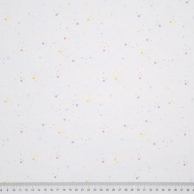 Pastel speckled spots printed on a white, 100% cotton fabric with a cm ruler at the bottom