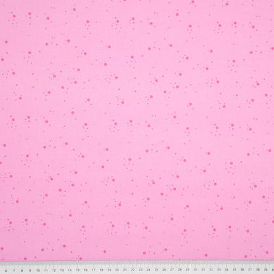 Dark pink speckled spots printed on a candy pink, 100% cotton fabric with a cm ruler at the bottom