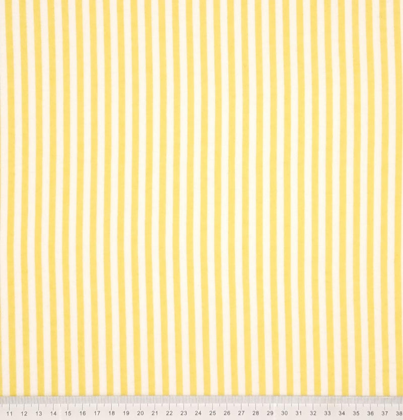 Yellow and white candy stripes printed on a soft brushed polycotton winceyette with a cm ruler at the bottom
