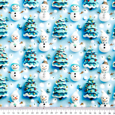 Pattern of snowmen and Christmas trees on a blue polycotton fabric with a ruler at the bottom.