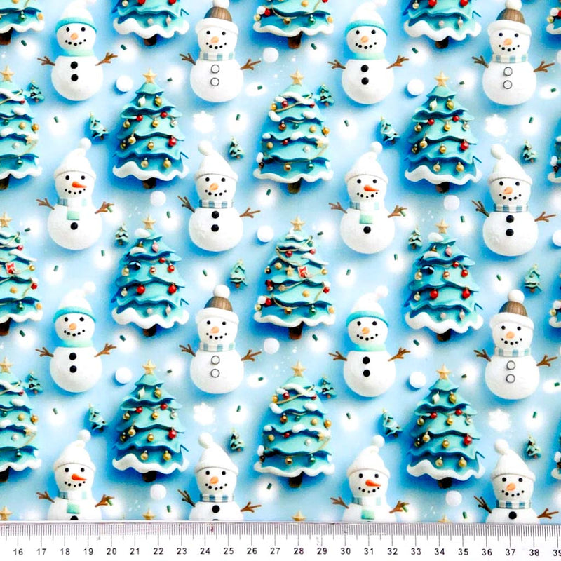 Pattern of snowmen and Christmas trees on a blue polycotton fabric with a ruler at the bottom.