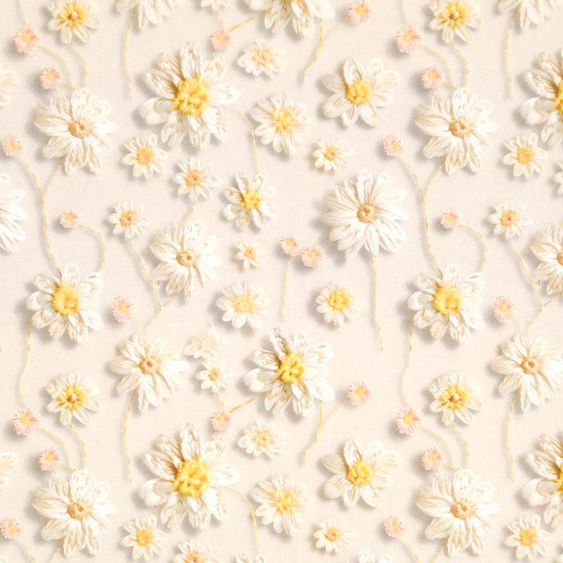 Pattern of white flowers with yellow centers on a light beige background printed on a cotton fabric