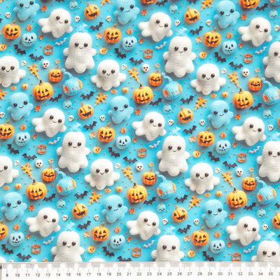 Halloween-themed fabric with crochet ghosts, pumpkins, and bats on a blue cotton fabric