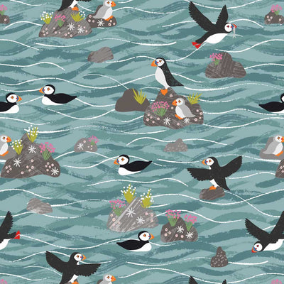 Puffins on rocks in a coastal scene in sea blue, printed on a cotton quilting fabric
