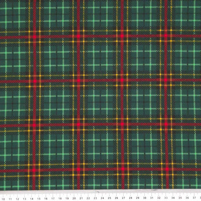 A festive bottle green and red tartan printed on a polycotton fabric with a cm ruler