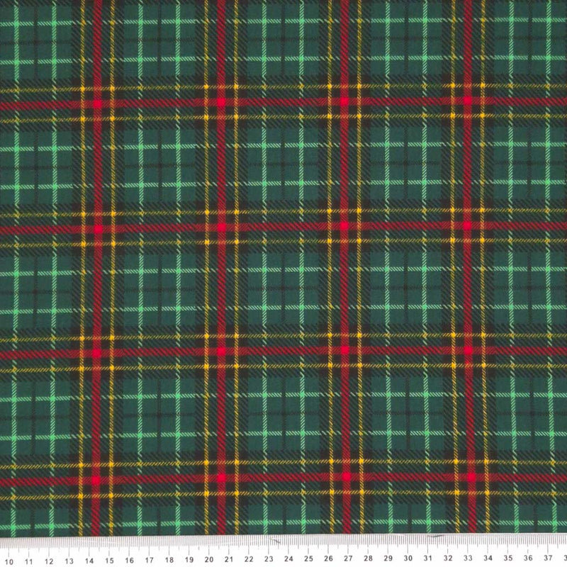 A festive bottle green and red tartan printed on a polycotton fabric with a cm ruler