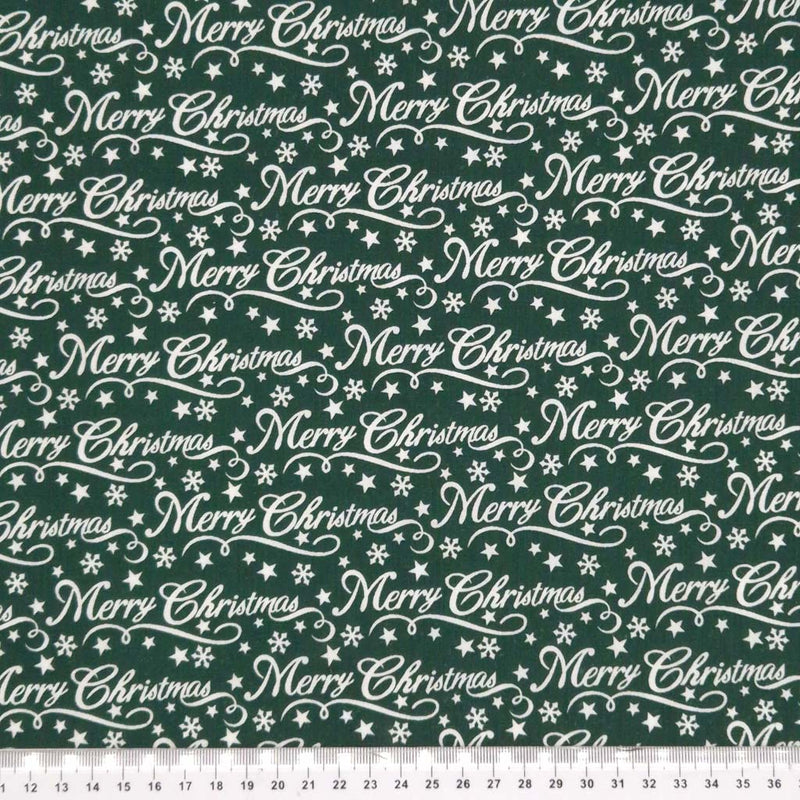 Merry christmas message printed on a bottle green polycotton fabric with a cm ruler