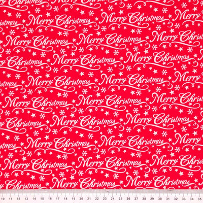 Merry christmas message printed on a red polycotton fabric with a cm ruler