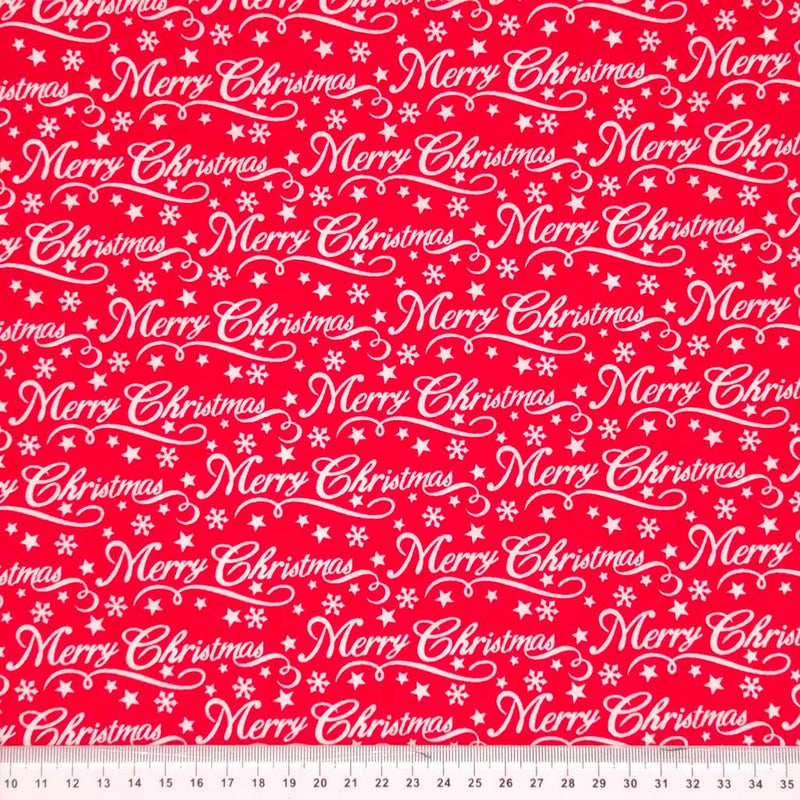 Merry christmas message printed on a red polycotton fabric with a cm ruler