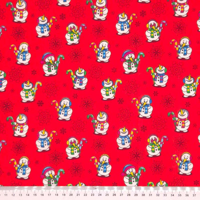 Festive snowmen printed on  red polycotton fabric with a cm ruler