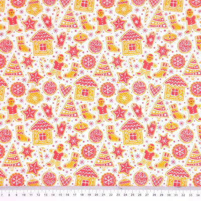 Gingerbread people and houses printed on a white polycotton fabric with a cm ruler